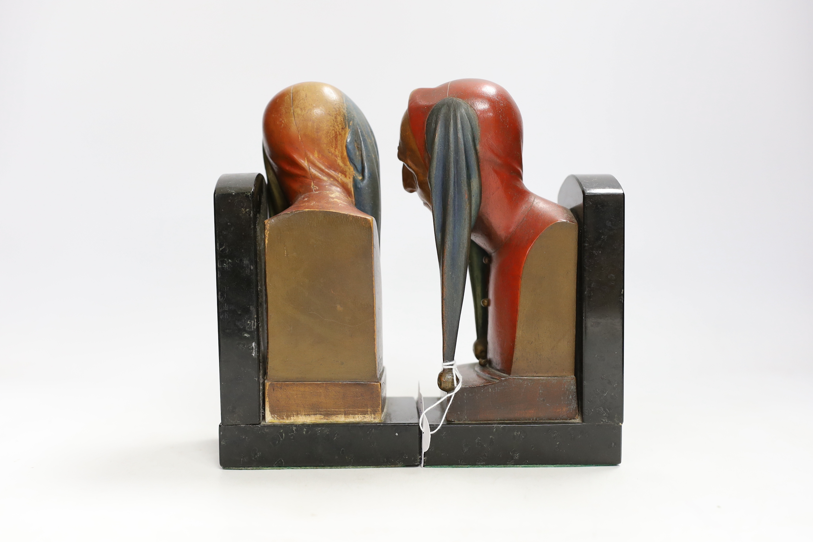 A pair of Gotthard Sonnenfeld painted wood bookends, granite bases, engraved, N.D.M, both with busts of jesters, 20cm high